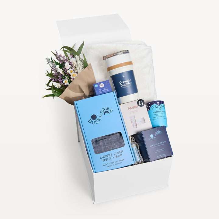 Comfort &amp; Care Cream + Blue Deluxe, white gift box, lid open. Cream throw, dried bouquet, Luxury Linen Neck Wrap, Ceramic Tumbler, Peaceful Pause tea, Sea Salt &amp; Orchid candle, Paume, lip butter. Giften Market.