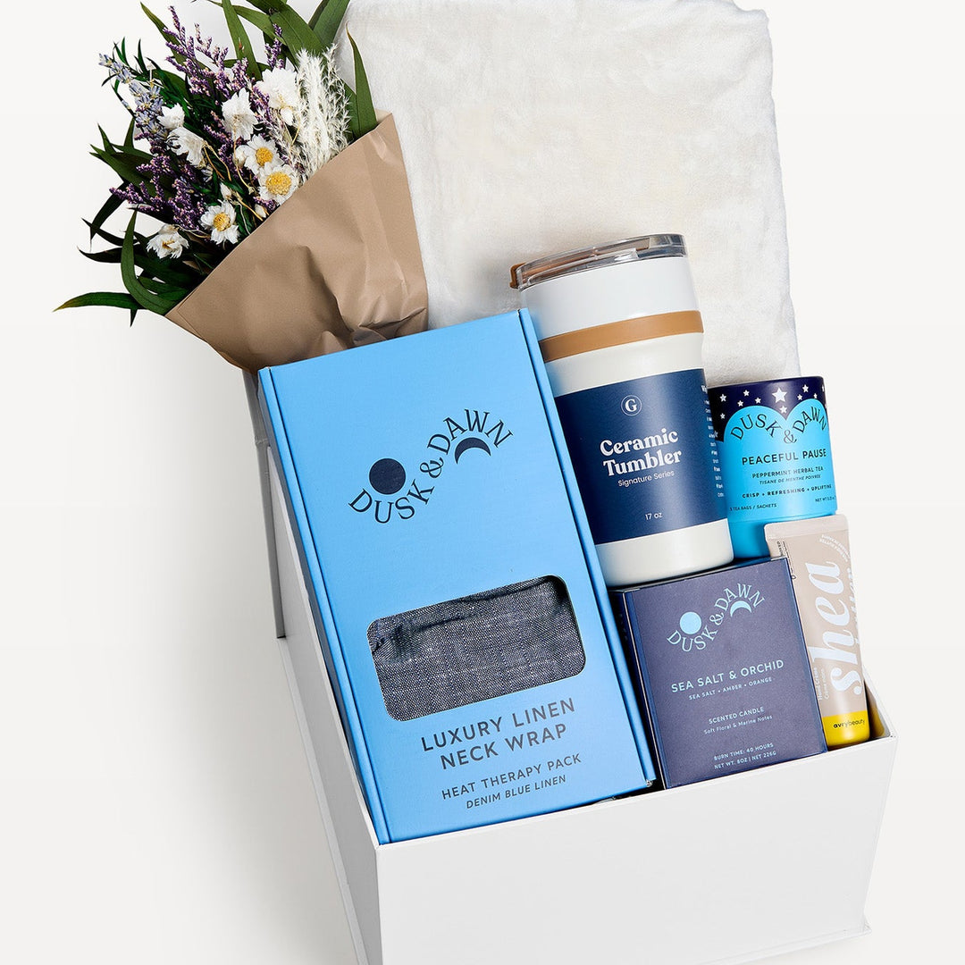 Comfort &amp; Care Gift Box Cream + Blue Classic, close-up of the open white gift box: Luxury Linen Neck Wrap, Ceramic Tumbler, dried bouquet, Peaceful Pause tea, Sea Salt &amp; Orchid candle, Shea bar. Giften Market.