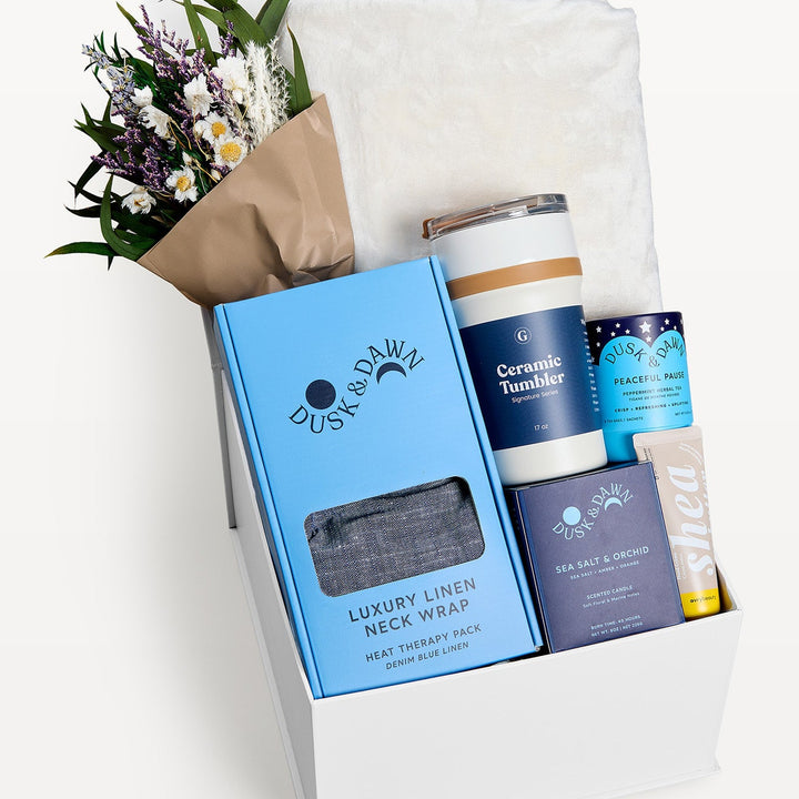 Comfort &amp; Care Gift Box Cream + Blue Classic, close-up of the open white gift box: Luxury Linen Neck Wrap, Ceramic Tumbler, dried bouquet, Peaceful Pause tea, Sea Salt &amp; Orchid candle, Shea bar. Giften Market.