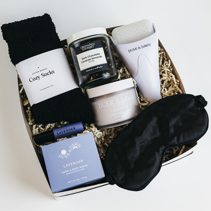 Gift set with socks, candles, and a eye mask on a white background