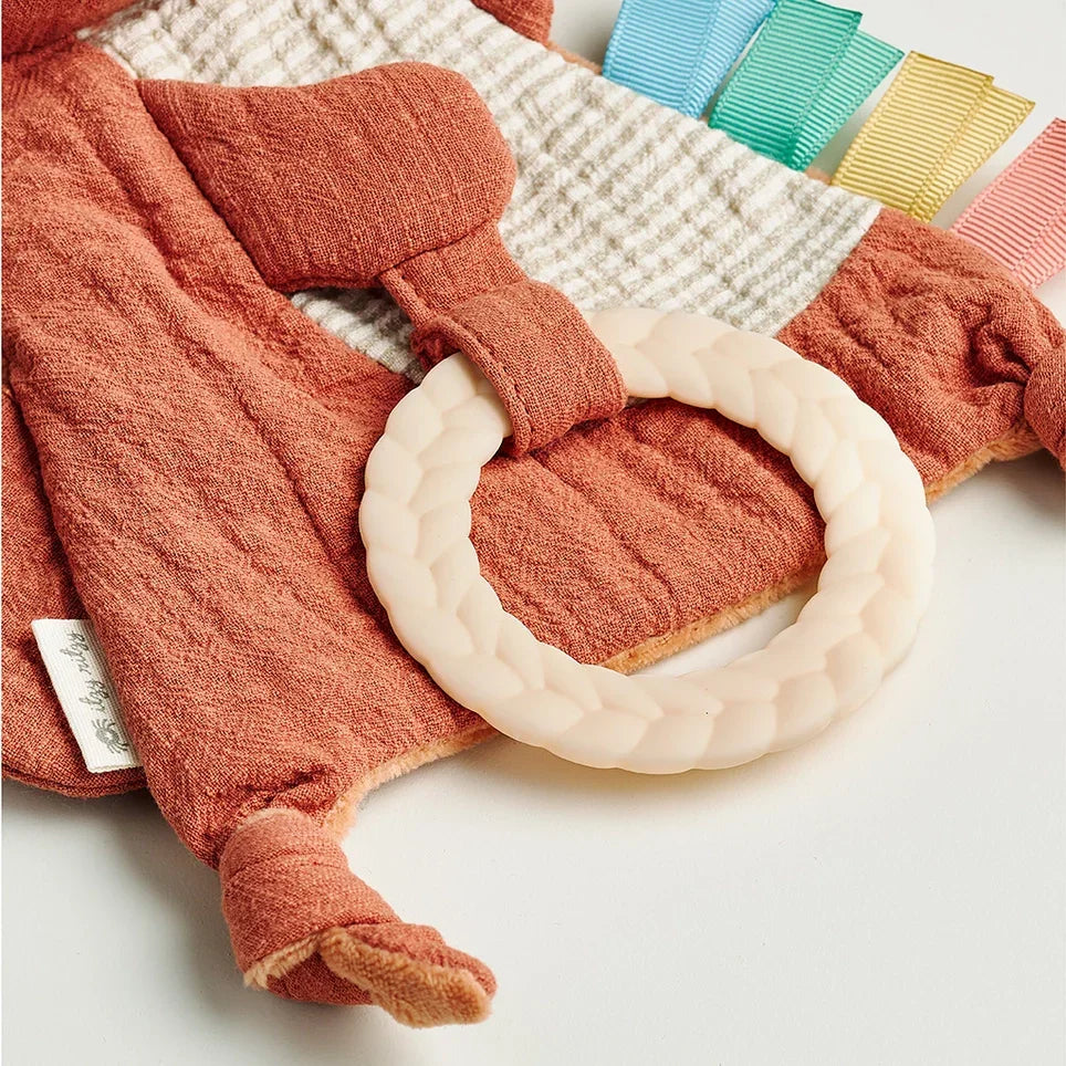 Rust-colored fox sensory baby toy with silicone teether and multicolored ribbon tags