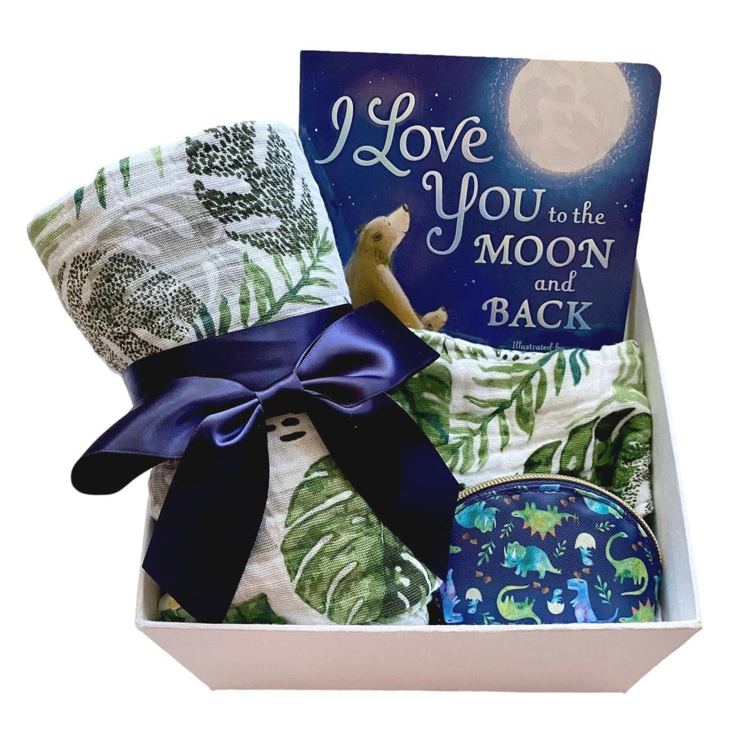 Baby gift box with board book, leafy swaddle blanket, navy ribbon, and dinosaur pouch