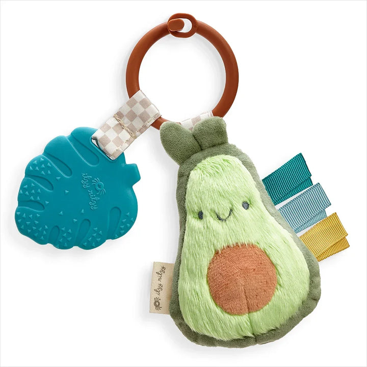 Plush avocado baby teether with blue silicone leaf and colorful ribbon tags on a brown ring