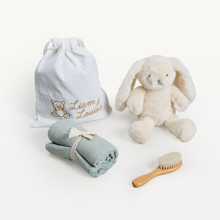 Liam &amp; Louisa Snuggle Set, Bea Bunny in sage green, loose on the sweep: drawstring bag, cream bunny, rolled sage swaddle, wooden brush. Giften Market.