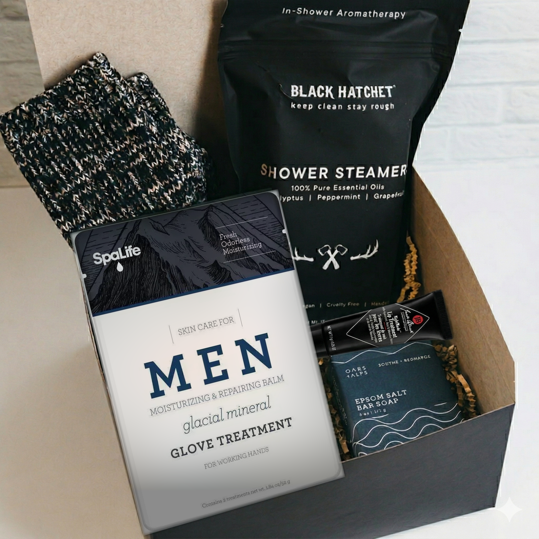 Men's self-care gift box with Black Hatchet shower steamers, SpaLife glacial mineral hand glove treatment, Oars + Alps epsom salt bar soap, cozy socks and Jack Black lip treatment
