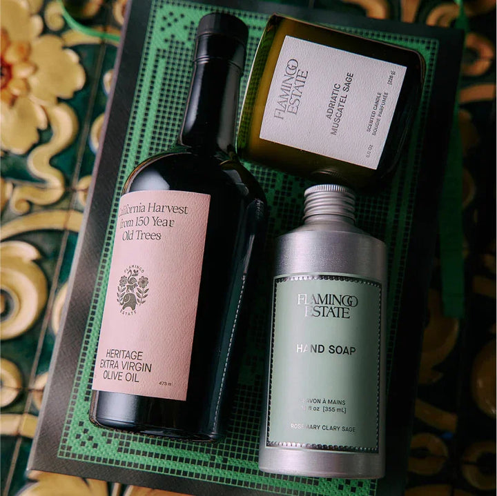 Gift box with olive oil, scented candle, and hand soap on decorative tray