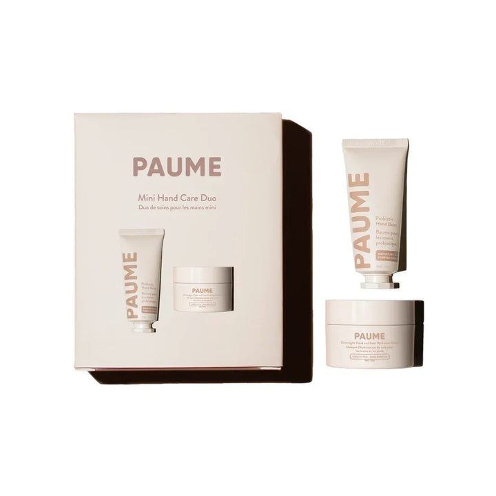 Paume Mini Hand Care Boxed Set with blush box, hand cream tube and hand balm jar on a cream background