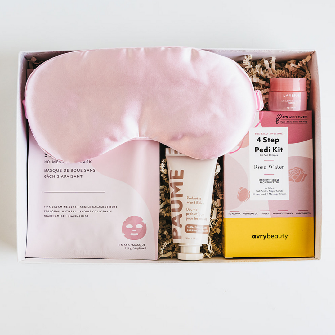Skincare and beauty product set with a pink eye mask, cream, and pedicure kit in a box on a white background.