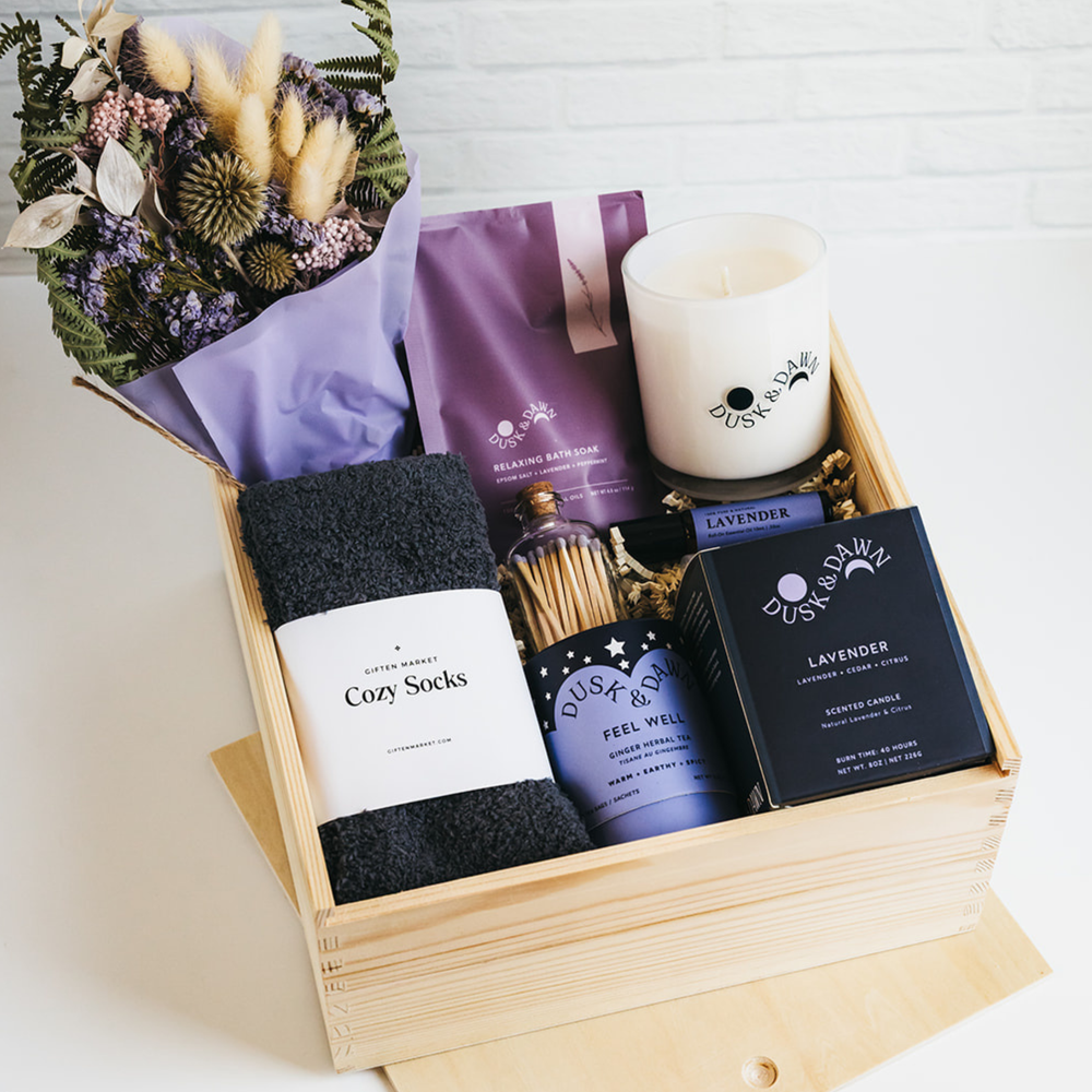 Luxury wooden gift box with cozy socks, lavender candle, bath soak, herbal tea, matches, and dried flowers