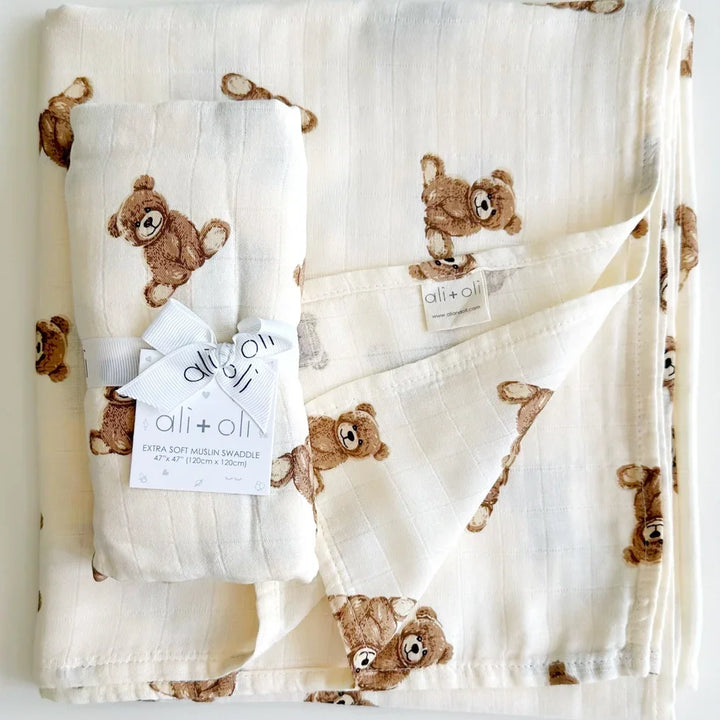 Muslin baby swaddle blanket with teddy bear print, ribbon-wrapped for gifting