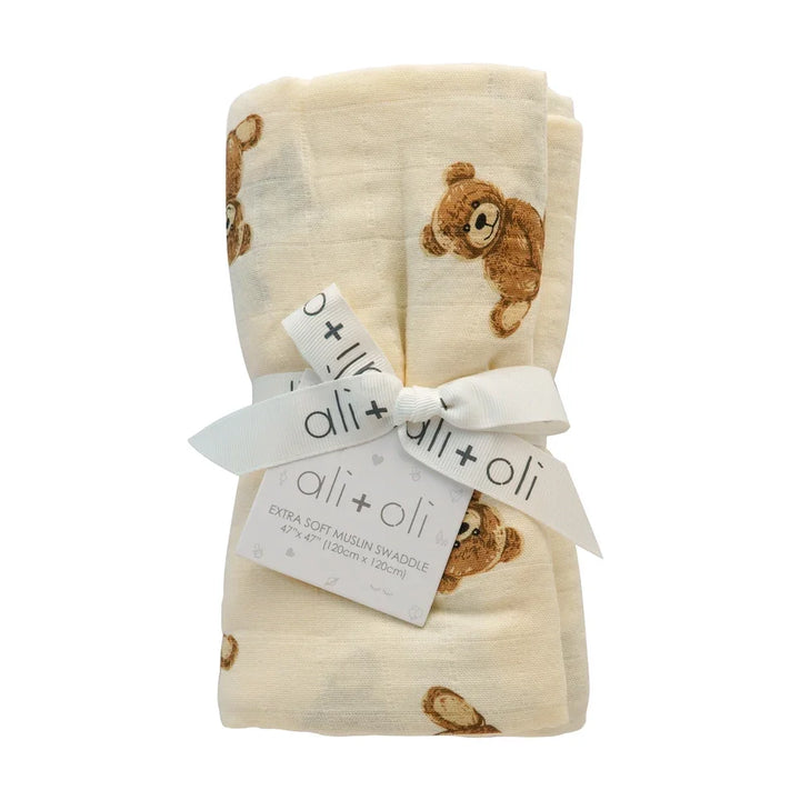 Bamboo muslin baby swaddle blanket with teddy bear print, tied with branded ribbon